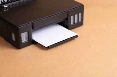 Close-Up Of New Inkjet Printer With Paper On Brown Wooden Table Background With Copyspace.