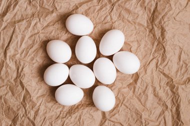 Fresh White Eggs On Background Of Brown Crumpled Paper At Easter Top View.