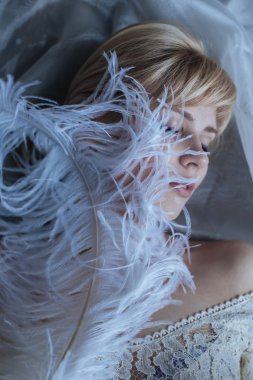 Devekuşu tüyü olan güzel kadın.