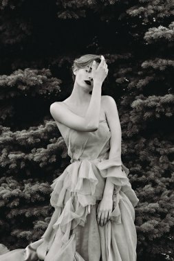 Siyah beyaz fotoğraf güzel kız ormanda poz.