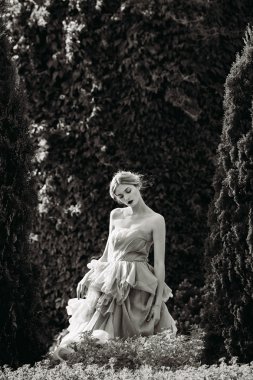 Siyah beyaz fotoğraf güzel kız ormanda poz.