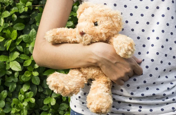 Urso de peluche no braço de uma jovem mulher — Fotografia de Stock