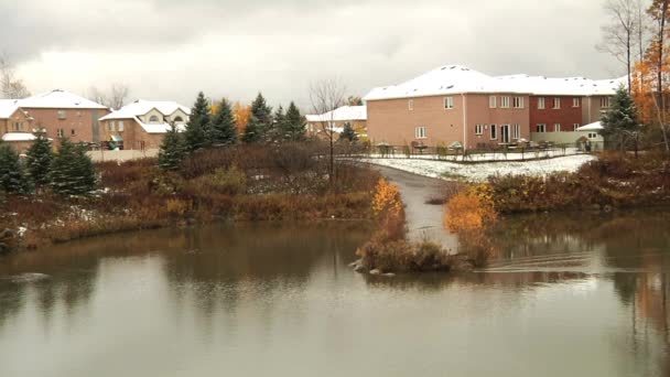 Teich im Park und Schnee auf den Dächern. — Stockvideo