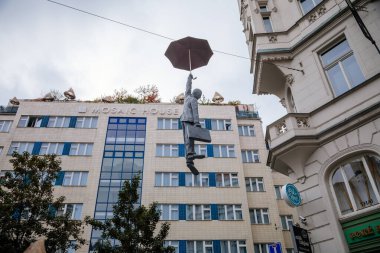 Mozaik Evi Tasarım Oteli ve Prag 'ın merkezinde, Çek Cumhuriyeti, Bohemya Bölgesi, 11 Ekim 2020' de, sonbahar gününde şemsiye üzerinde uçan bir adamın heykeli. 