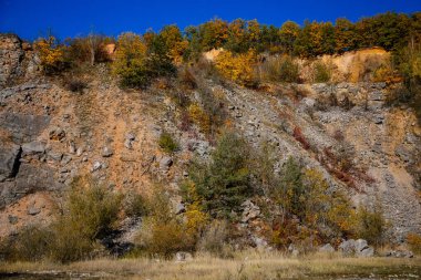 Sonbahar ormanı, güneşli bir günde dağlar, Solvay ocakları (Solvayovy lomy), Uçurumun altında Aziz John (Svaty Jan pod Skalou), Çek Cumhuriyeti, 24 Ekim 2020