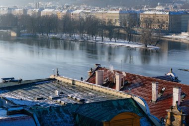Prag 'ın panoramik manzarası, güneşli kış gününde kar ve Vltava Nehri ile kaplı çatılar, Eski Şehir Köprüsü Kulesi, Prag, Çek Cumhuriyeti, 18 Aralık 2017