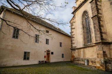 Eski okul binası ve ortaçağ Katolik kilisesi Aziz Peter ve Paul Kilisesi güneşli bir sonbahar gününde Melnik Kalesi, Yüksek Saat Kulesi, Merkez Bohemya, Çek Cumhuriyeti, 14 Kasım 2020