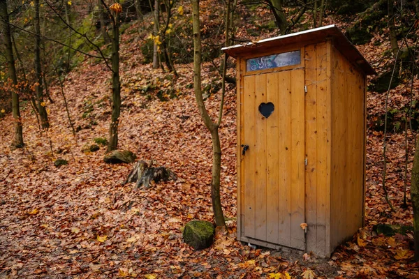 Countryside wooden toilet in a village, old door with a heart in the forest, Hiking Golden Trail of Bohemian Paradise near Vranov castle and Pantheon, Mala Skala, Czech Republic, November 21, 2020 — Stock Image Countryside Wooden Toilet Village Old Door Heart Forest Hiking Golden Stock Image