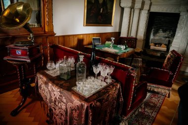 Radun şatosu, Neo-Klasik şato, kütüphane ve kitaplıklar, masa örtüsü, bardak ve şişeler, büyük taş şömine, koltuklar ve gramofon, Çek Cumhuriyeti, Temmuz 06, 2018