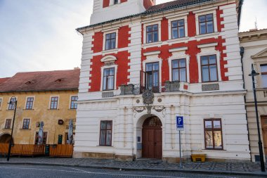 Tarihi ortaçağ kraliyet kasabası Slany 'nin ana Masaryk Meydanı' ndaki eski belediye binası güneşli kış gününde renkli Rönesans evleri, Orta Bohemya, Çek Cumhuriyeti, 27 Aralık 2020 