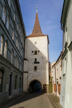 Velvary Kapısı 'nın gotik kulesi, güneşli bir günde inşa edilen kasaba tahkimatları, tarihi ortaçağ şehri Slany' ın caddesi, Merkez Bohemya, Çek Cumhuriyeti, 27 Aralık 2020