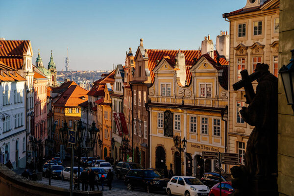 Narrow picturesque historic Nerudova street with baroque and renaissance buildings, next to Prague Castle. Royal Way or Kings Road, Lesser Town in sunny day, Prague, Czech Republic, December 31, 2020