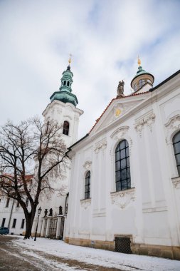 Beyaz Barok kilisesi olan Strahov Manastırı, kar altında Bohemya Premonstratensian Manastırı, kış gününde Bakire Meryem Bazilikası, Hradcany, Prag, Çek Cumhuriyeti, 17 Ocak 2021
