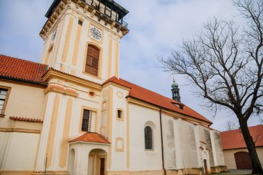 Rönesans kalesi yakınlarındaki Meryem Ana 'nın Doğumu Kilisesi, parklı şato güneşli kış gününde bahçedeki patika Benatky nad Jizerou, Orta Bohem Cumhuriyeti, Çek Cumhuriyeti, 01 Ocak 2021