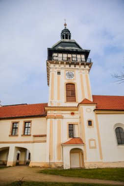 Rönesans kalesi yakınlarındaki Meryem Ana 'nın Doğumu Kilisesi, parklı şato güneşli kış gününde bahçedeki patika Benatky nad Jizerou, Orta Bohem Cumhuriyeti, Çek Cumhuriyeti, 01 Ocak 2021