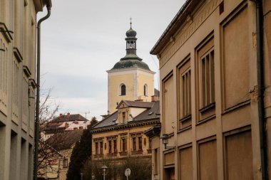 Kışın barok ve rönesans tarihi binaları olan dar ortaçağ resimli cadde, Aziz Nicholas Kilisesi 'nin çan kulesi, Bohemya Cenneti, Turnov, Çek Cumhuriyeti, 01 Ocak 2021