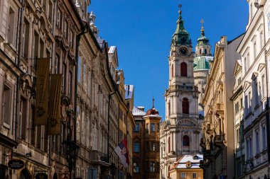 Mostecka Caddesi, Barok Aziz Niklas Kilisesi manzaralı, tarihi binaları olan eski kasaba, güneşli kış günü, Mala Strana veya Küçük Şehir Bölgesi, Prag, Çek Cumhuriyeti, 14 Şubat 2021