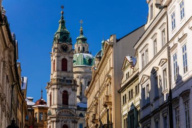 Aziz Niklas Barok Kilisesi manzarası, saatli yeşil kubbe ve çan kulesi, güneşli kış günü, kırmızı çatılarda kar, Mala Strana veya daha küçük kasaba bölgesi, Prag, Çek Cumhuriyeti, 14 Şubat 2021