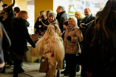 Gece geçit töreninde küçük Krampus, Korkunç kürk kostümlü ve boynuzlu maskeli insanlar sokaklarda yürüyor, Geleneksel gösteri, Noel, tarihi sokak Getreidegasse, Salzburg, Avusturya, 05 Aralık 2017