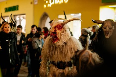 Krampus gece yürüyüşü, korkunç kürk kostümlü ve boynuzlu maskeli insanlar sokakta yürüyor, geleneksel gösteri Noel 'den önce, tarihi cadde Getreidegasse, Salzburg, Avusturya, 05 Aralık 2017