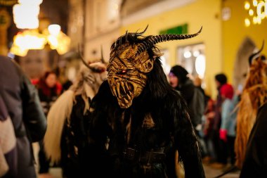 Krampus gece yürüyüşü, korkunç kürk kostümlü ve boynuzlu maskeli insanlar sokakta yürüyor, geleneksel gösteri Noel 'den önce, tarihi cadde Getreidegasse, Salzburg, Avusturya, 05 Aralık 2017
