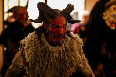 Krampus gece yürüyüşü, korkunç kürk kostümlü ve boynuzlu maskeli insanlar sokakta yürüyor, geleneksel gösteri Noel 'den önce, tarihi cadde Getreidegasse, Salzburg, Avusturya, 05 Aralık 2017