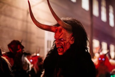Krampus gece yürüyüşü, korkunç kürk kostümlü ve boynuzlu maskeli insanlar sokakta yürüyor, geleneksel gösteri Noel 'den önce, tarihi cadde Getreidegasse, Salzburg, Avusturya, 05 Aralık 2017
