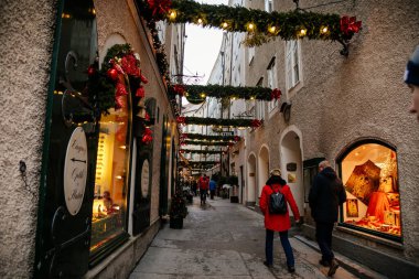 Goldgasse veya Golden Street 'te el yapımı renkli tatil süslemeleri, eski kasaba, geleneksel gelişim, Salzburg, Avusturya merkezindeki yeşil Noel ağacı dalları, 05 Aralık 2017