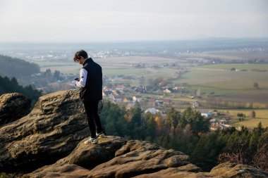Drabske svetnicky 'den hava manzarası, güneşli bir günde Bohemya Cenneti' nin sonbahar kumtaşı manzarası, Kum Taşı kayalıkları, insan taşın üzerine oturur, Çek Cumhuriyeti, 05 Aralık 2020