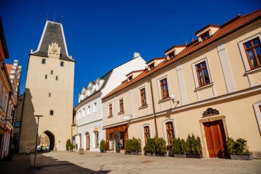 Gotik saat kulesi Mikulov Kapısı, Dar resim caddesi rengarenk Rönesans ve barok binalar ile tarihi şehir, güneşli gün, Kadan, Çek Cumhuriyeti, Nisan 04, 2021