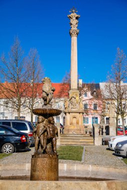 Barok aslan çeşmesi, dans eden çocuklardan oluşan heykel grubu, ana meydan, eski kasaba, rönesans barok tarihi binalar, Kutsal Üçlü Sütun, Klasterec nad Ohri, Çek Cumhuriyeti, Nisan 04, 2021