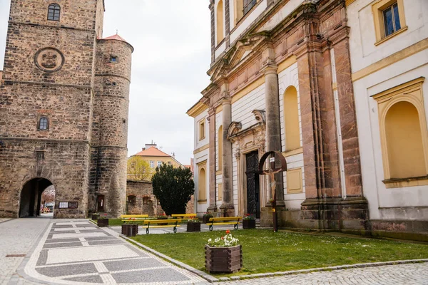 Galerisi ve saati olan ortaçağ gotik kulesi, Valdice kapısı veya Valdicka brana, güneşli bir günde Büyük St. James 'in barok kilisesi, Bohemya Cenneti veya Cesky Raj, Jicin, Çek Cumhuriyeti, 01 Mayıs 2021