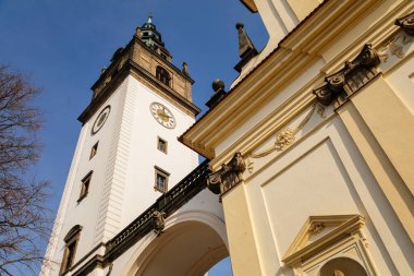 Beyaz ve sarı barok St. Stephens Katedrali, Dome Meydanı 'nda, Kilisenin saat kulesi, güneşli bir günde, taş kemer, mavi gökyüzü, Litomerice, Çek Cumhuriyeti, 20 Şubat 2021