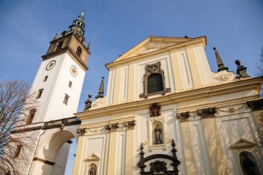 Beyaz ve sarı barok St. Stephens Katedrali, Dome Meydanı 'nda, Kilisenin saat kulesi, güneşli bir günde, taş kemer, mavi gökyüzü, Litomerice, Çek Cumhuriyeti, 20 Şubat 2021