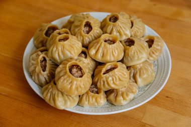 Buharda pişirilmiş milli Moğol yemeği köfte Buuz kıyma, beyaz tabak, ahşap masa Doğu Sibirya Buryats çanak poz, Sulu kıymalı el yapımı hamur gömleği, üst görünümde.