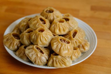 Buharda pişirilmiş milli Moğol yemeği köfte Buuz kıyma, beyaz tabak, ahşap masa Doğu Sibirya Buryats çanak poz, Sulu kıymalı el yapımı hamur gömleği, üst görünümde.