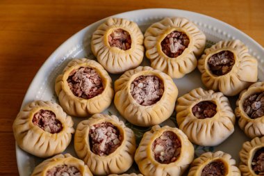 Buharda pişirilmiş ulusal Moğol yemeği köfteleri kıyma, beyaz tabak, ahşap masa Doğu Sibirya Buryatları çanak pozları sulu kıymalı el yapımı hamur tişörtü, buuza 