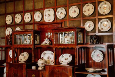 Kale içi, büfe, porselen kaplar, tabaklar, duvarlardaki tahta panellere asılan çiçek desenleri, ahşap mobilyalar, akşam yemeği için hazırlanan masa, Nove mesto nad Metuji, Çek Cumhuriyeti, 12 Haziran 2021