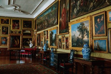 Kale içi, sanat galerisi, barok döşeli mobilyalar kırmızı döşeme, kanepe ve koltuklar, duvarlarda yaldızlı çerçeveler, Rönesans şatosu Opocno, Çek Cumhuriyeti, 12 Haziran 2021