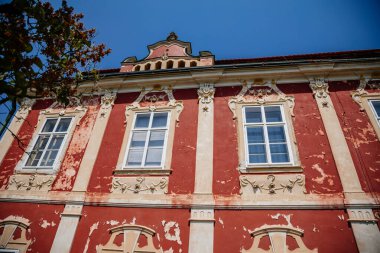 Barok kalesi Steknik, sıva, koyu kırmızı alçı, kırmızı kiremit çatı, yeşil çimen, italyan bahçesi, güneşli yaz gününde aristokratik konut, antik şato Steknik, Çek Cumhuriyeti, 19 Haziran 2021