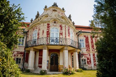 Barok kalesi Steknik, sıva, koyu kırmızı alçı, kırmızı kiremit çatı, yeşil çimen, italyan bahçesi, güneşli yaz gününde aristokratik konut, antik şato Steknik, Çek Cumhuriyeti, 19 Haziran 2021
