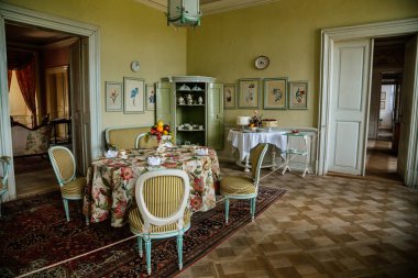 Krasny Dthe Chateau, Kuzey Bohemya, Çek Cumhuriyeti, 19 Haziran 2021: Şato içi, yemek odasında beyaz rokoko mobilya, tabaklar, pasta ve meyveli barok dolap.