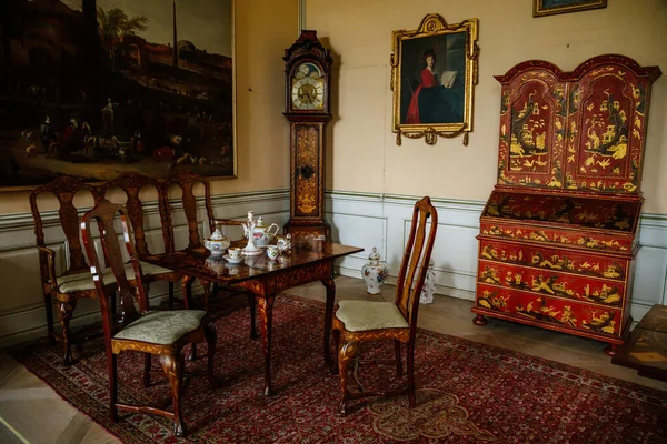 クラスニー ドヴール城 北ボヘミア チェコ共和国 2021年6月19日 城の内部 バロック様式の家具 リビングルームの木製の椅子とお茶セット 秘書とアンティーク祖父時計とテーブルを彫刻 — ストック写真
