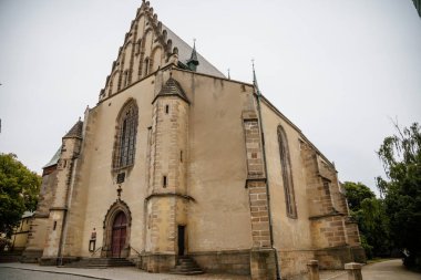 Rakovnik, Orta Bohem Bölgesi, Çek Cumhuriyeti, 19 Haziran 2021: St. Bartholomew Kilisesi 'nin yaz günü ana Husove Meydanı' ndaki kulesi ile Gotik Portalı 'na giriş.