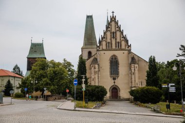 Rakovnik, Orta Bohem bölgesi, Çek Cumhuriyeti, 19 Haziran 2021: St. Bartholomew Kilisesi, yaz günü ana Husove Meydanı 'nda yarı ahşap zeminli büyük çan kulesi, Gotik portala giriş.