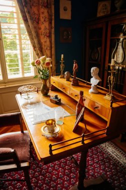 Velke Brezno, Çek Cumhuriyeti, 26 Haziran 2021: Şato Velke Brezno, barok mobilyalı kale içi, ahşap yazı masalı dolap, pencere kenarındaki koltuklar, biblolar ve belgeler.