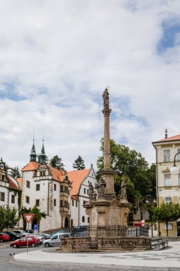 Benesov nad Ploucnici, Kuzey Bohemya, Çek Cumhuriyeti, 26 Haziran 2021: Kasaba meydanında barok heykelleri olan Marian Sütunu, güneşli yaz gününde eski Saksafon Rönesansı Morzinov Şatosu ve Belediye Binası.