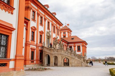 Prag, Çek Cumhuriyeti, 25 Nisan 2021: Troja kalesi, tarihi şato ve bahar günü bir bahçeyle çevrili kırmızı ve beyaz barok sarayı, taş heykellerle süslenmiş merdivenler.