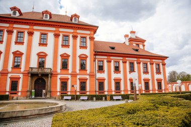 Prag, Çek Cumhuriyeti, 25 Nisan 2021: Troja kalesi, tarihi şato ve bahar günü bir bahçeyle çevrili kırmızı ve beyaz barok sarayı, taş heykellerle süslenmiş merdivenler.