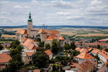 Mikulov, Güney Moravya Bölgesi, Çek Cumhuriyeti, 05 Temmuz 2021: Ortaçağ kasabasının havadan görünüşü, tepede taş duvarları, St. Wenceslas Kilisesi 'nin kulesi, güneşli yaz gününde kırmızı kiremit çatıları.